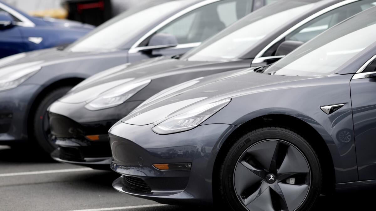 Model 3 sedans sit at a Tesla dealership in Littleton, Colo.
