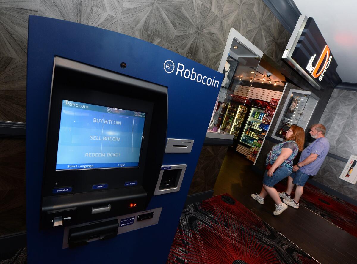 Guests walk by a newly installed Robocoin ATM that accepts bitcoins in Las Vegas.