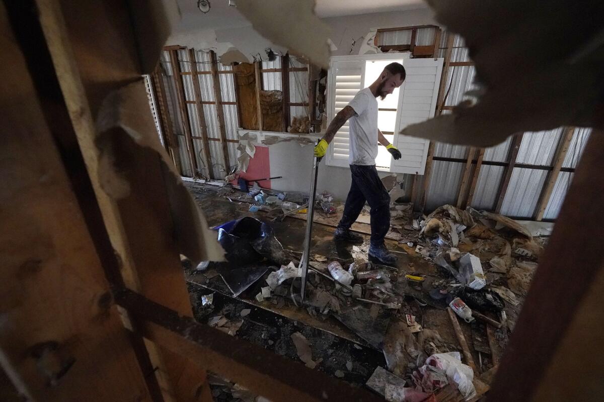 Un trabajador recoge escombros de una casa rodante que resultó dañada por el huracán Ian
