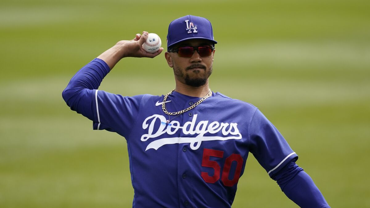 Dodgers right fielder Mookie Betts throws the ball as he warms up before a spring training game.