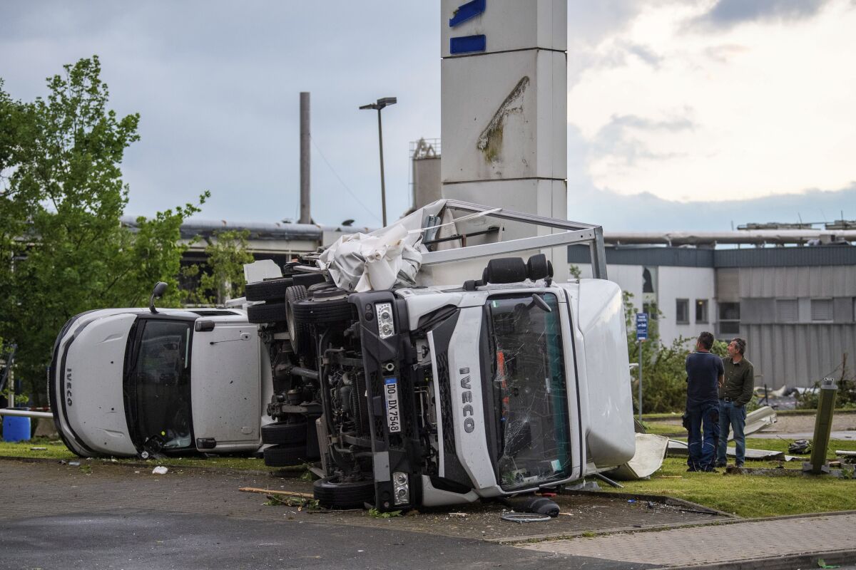 Two trucks overturned after a storm in Paderborn, Germany, Friday, May 20, 2022. A tornado swept through the western German city of Paderborn on Friday, injuring at least 30 people as it blew away roofs, toppled trees and sent debris flying for miles, authorities said. (Lino Mirgeler/dpa via AP)