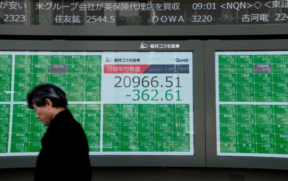 A man walks past an electronic board at the Tokyo Stock Exchange on Friday.