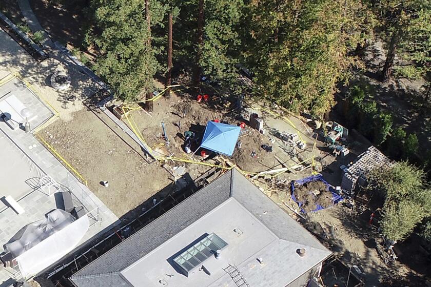 A mansion is under investigation by police after a car was found buried on the property the day before, in Atherton, Calif., Friday, Oct. 21, 2022. Three decades after a car was reported stolen in Northern California, police are digging the missing convertible out of the yard of a $15 million mansion built by a man with a history of arrests for murder, attempted murder and insurance fraud. (Nhat V. Meyer/Bay Area News Group via AP)