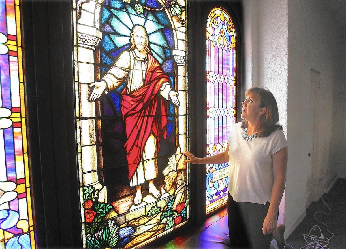 Senior Pastor Amy Aitken appreciates the popular stained glass window that adorns the entrance to First United Methodist Church in Costa Mesa.