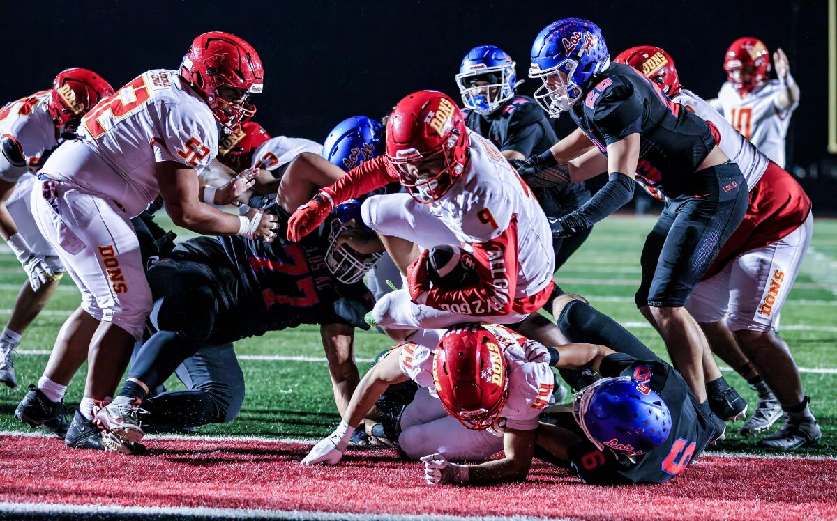 Los Alamitos falls to San Diego Cathedral in Division 1-AA regional soccer recreation 2 S.D. Cathedral running back Honor Fa'alave-Johnson jumps over a fallen blocker to cross the goal line against Los Alamitos.