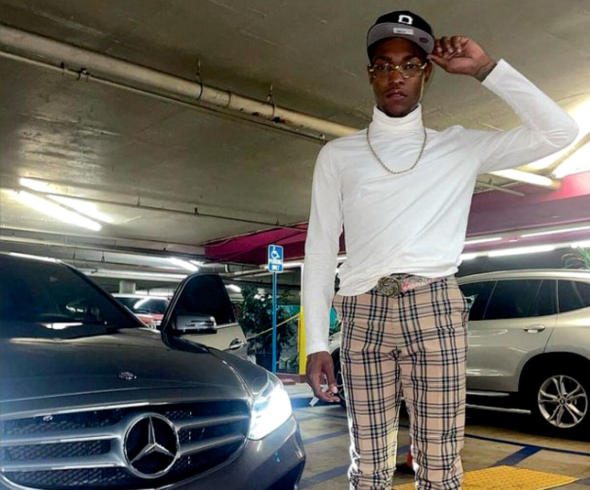 A man stands next to a Mercedes-Benz car in a parking garage