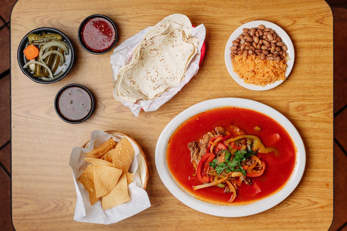 A serving of Beef Ranchero, chile de arbol spicy hot sauce, mild roasted red jalapenos, tomatillos and tomatoes with vinegar, jalapenos, bay leaves and garlic salsas with chips at Mi Ranchito Cafe, in Stockton, CA on May 23, 2025.