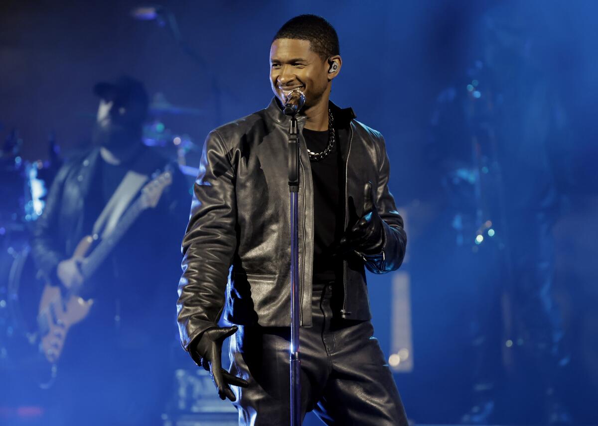 An R&B singer performs onstage in a black leather jacket