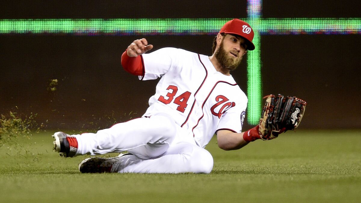 Nationals right fielder Bryce Harper slides to catch a fly ball in a game against Baltimore earlier this season.