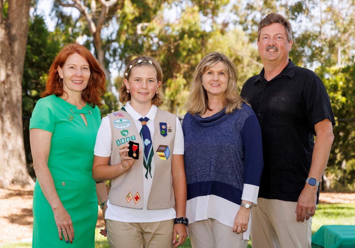 Carol Dedrich, Girl Scouts San Diego CEO, l to r, Amelia Umstadter (holding her medal) and parents, Anna and Karl Umstadter.