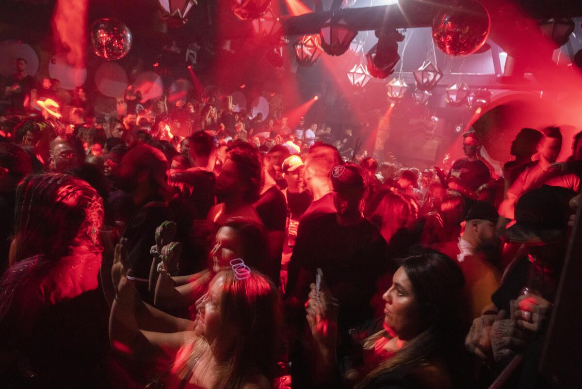 People stand in a big red-lighted room.