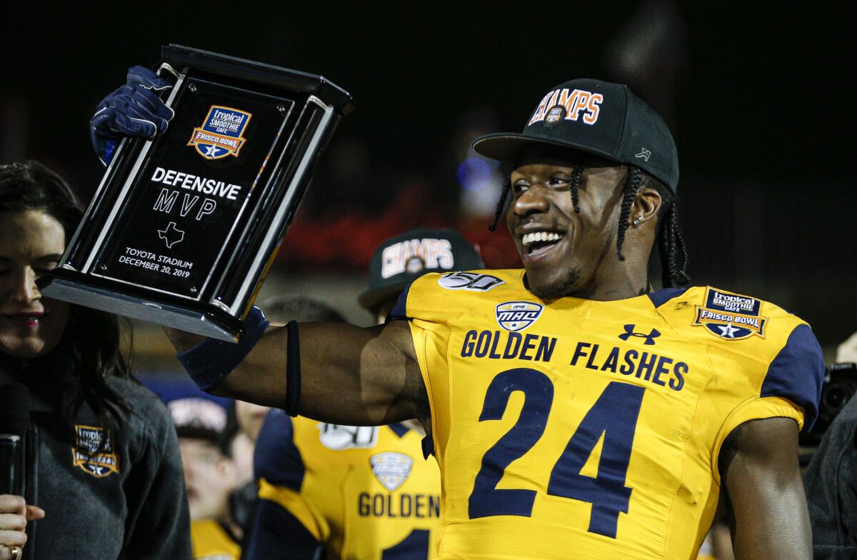 A smiling Qwuantrezz Knight holds his award for defensive MVP after the Frisco Bowl. 
