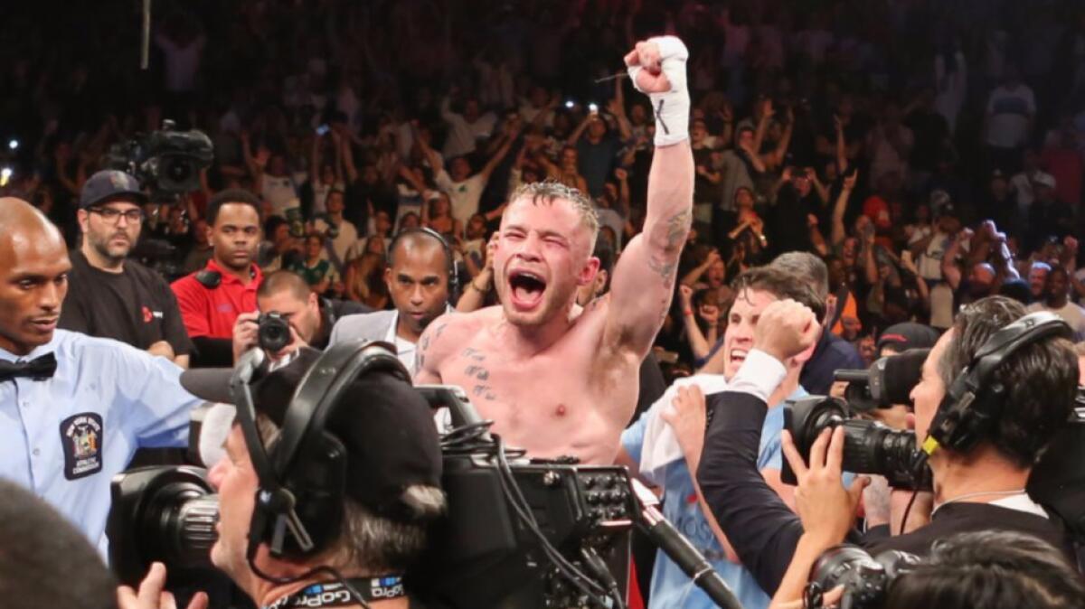 Carl Frampton celebrates after his win by decision over Leo Santa Cruz for the WBA featherweight title on July 30.