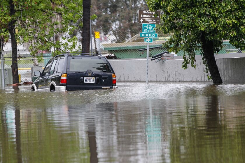 A car sits in an area flooded by heavy rain and the rising San Diego River along Hotel Circle Place in Mission Valley next to Sefton Fields on April 10, 2020 in San Diego, California.