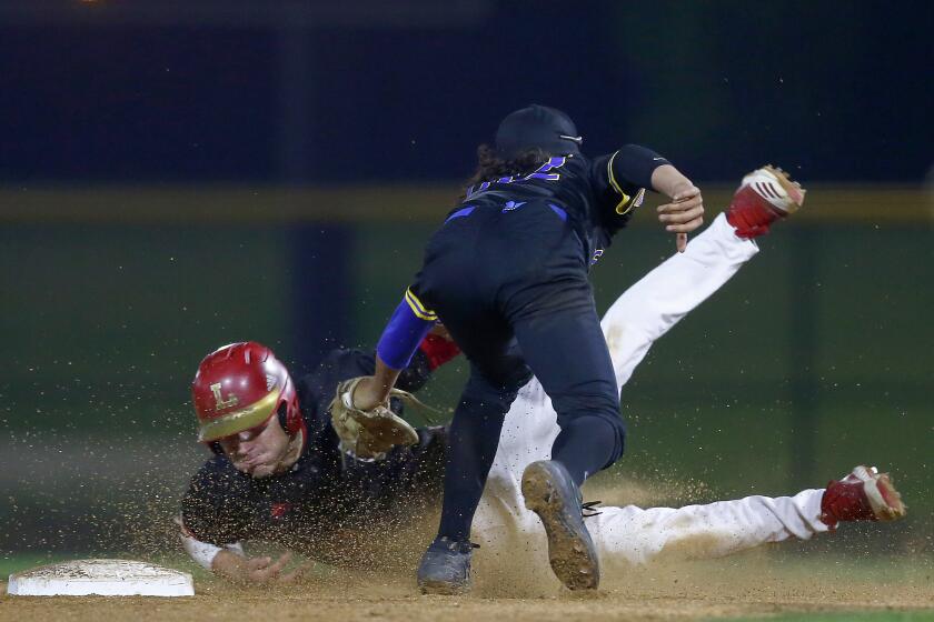 IRVINE, CALIF. - FEB. 19, 2020. La Mirada shorstop Jimmy Blumberg catches Orange Lutheran infielder Tank Espalin trtying to steal during a 2-0 Lancer victory over at the Great Park Baseball Stadium in Irvine on Wednesday, Feb. 19, 2020. (Luis Sinco/Los Angeles Times)