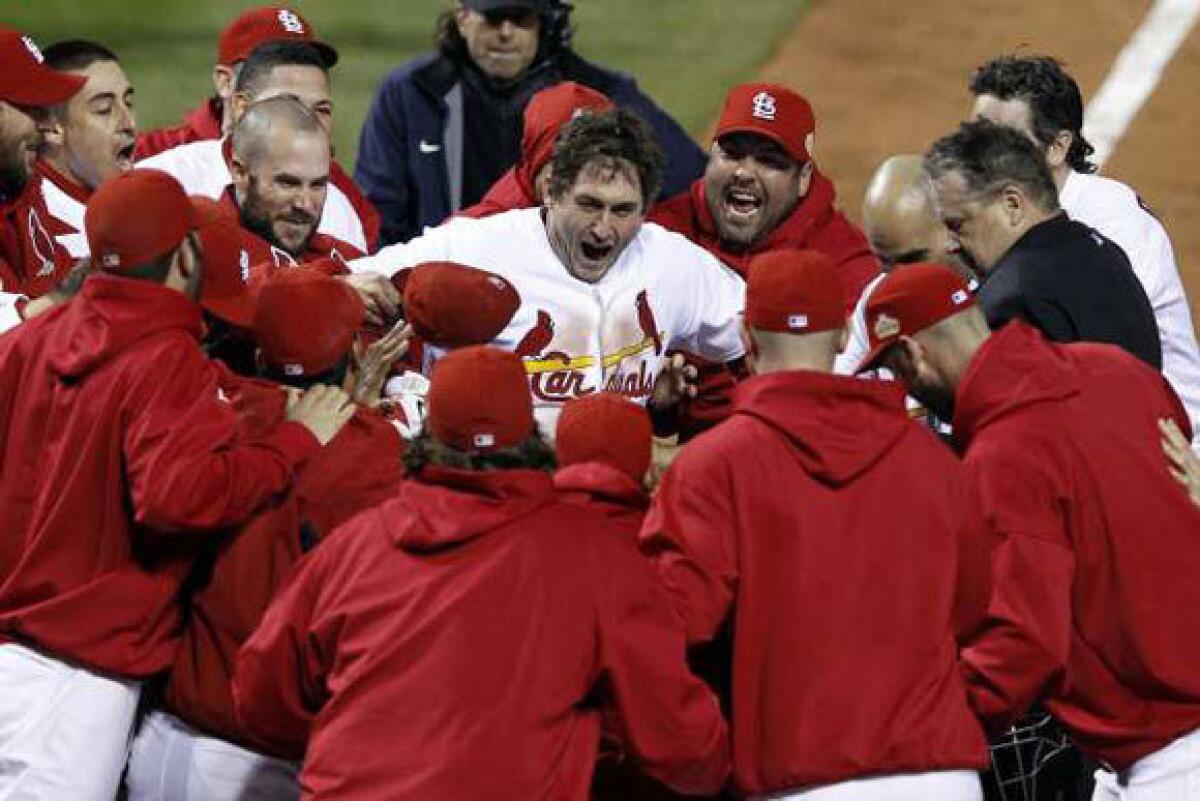 St. Louis Cardinals' David Freese, center, celebrates with teammates after hitting a walk-off home run in the 11th inning of Game 6 of the 2011 World Series.