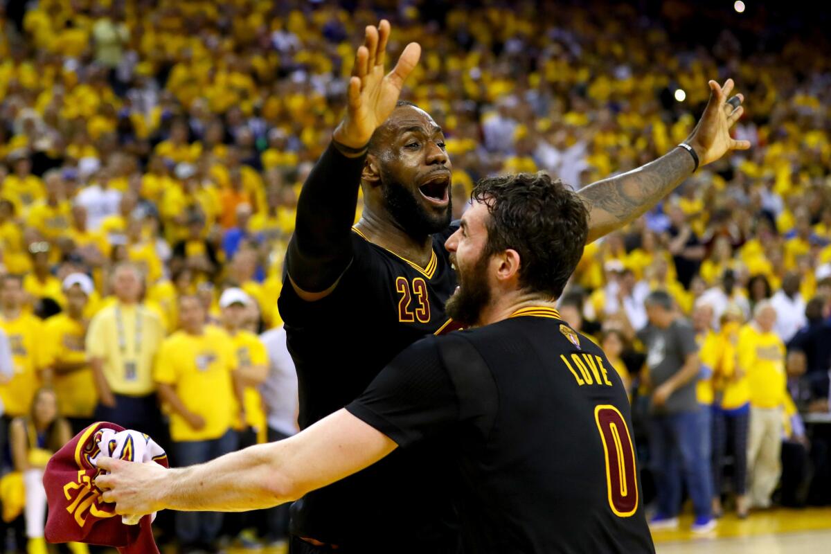 The Cleveland Cavaliers' LeBron James and Kevin Love celebrate after defeating the Golden State Warriors in the NBA Finals at Oracle Arena in Oakland on June 19.