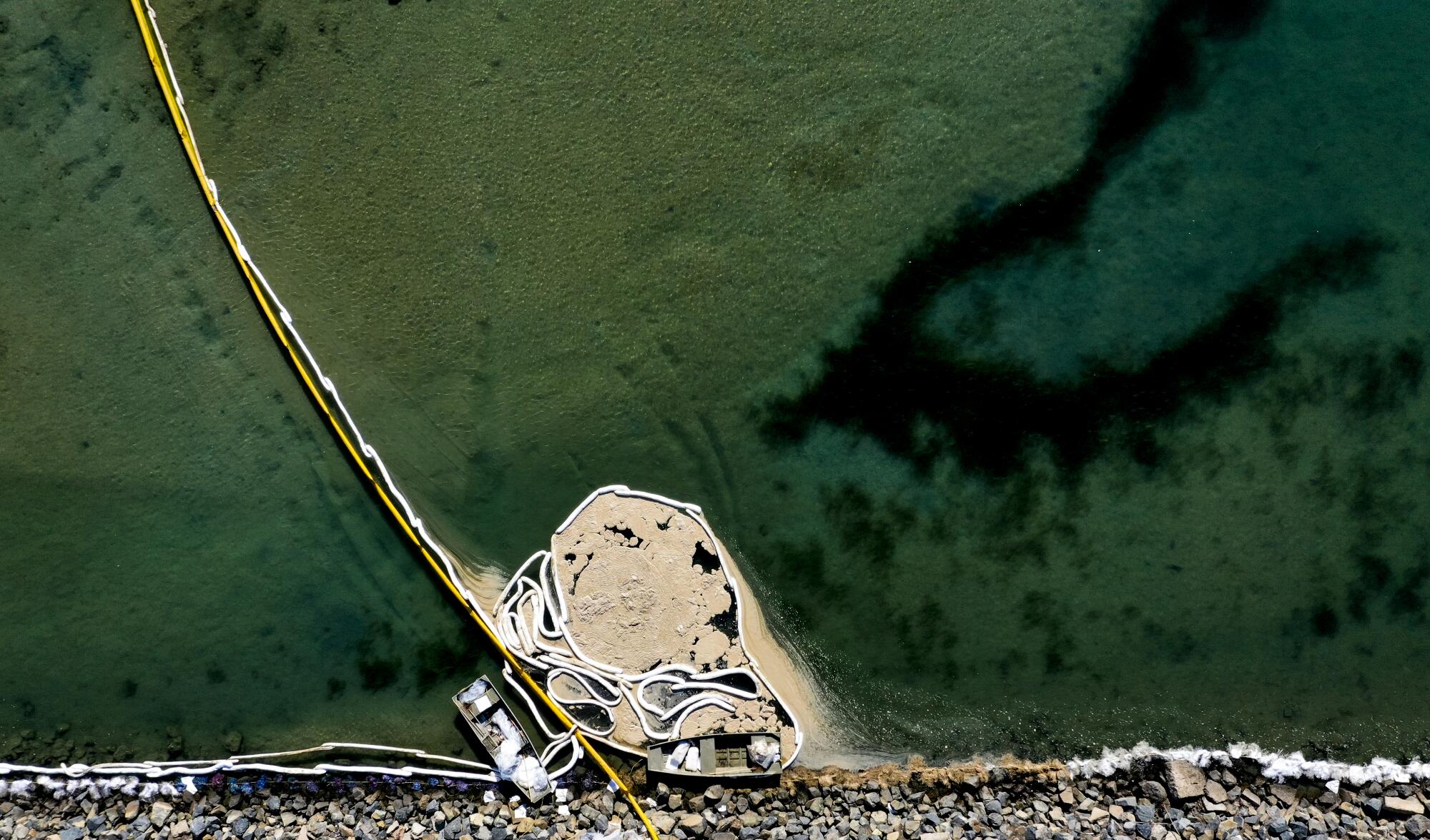 An aerial view of oil booms holding back contaminated water