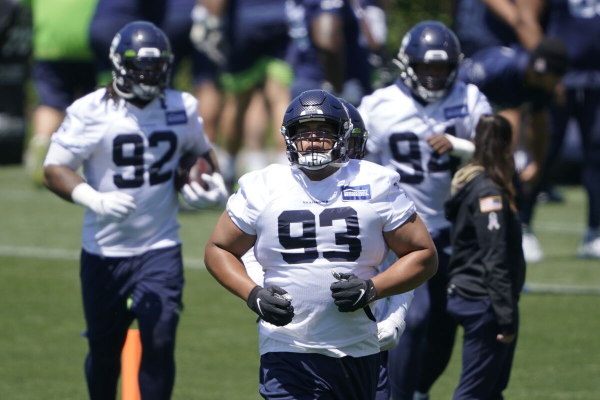FILE - In this June 16, 2021, file photo, Seattle Seahawks' Al Woods (93) runs between drills during NFL football practice in Renton, Wash. Woods always intended to continue his NFL career, even when he decided to join the small pool of players who opted out of the 2020 season due to the COVID-19 pandemic. (AP Photo/Ted S. Warren, File)