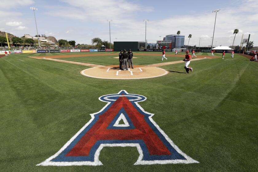 The Los Angeles Angels take the field to start a spring training baseball game against the Colorado Rockies, Sunday, Feb. 23, 2020, in Tempe, Ariz. (AP Photo/Gregory Bull)