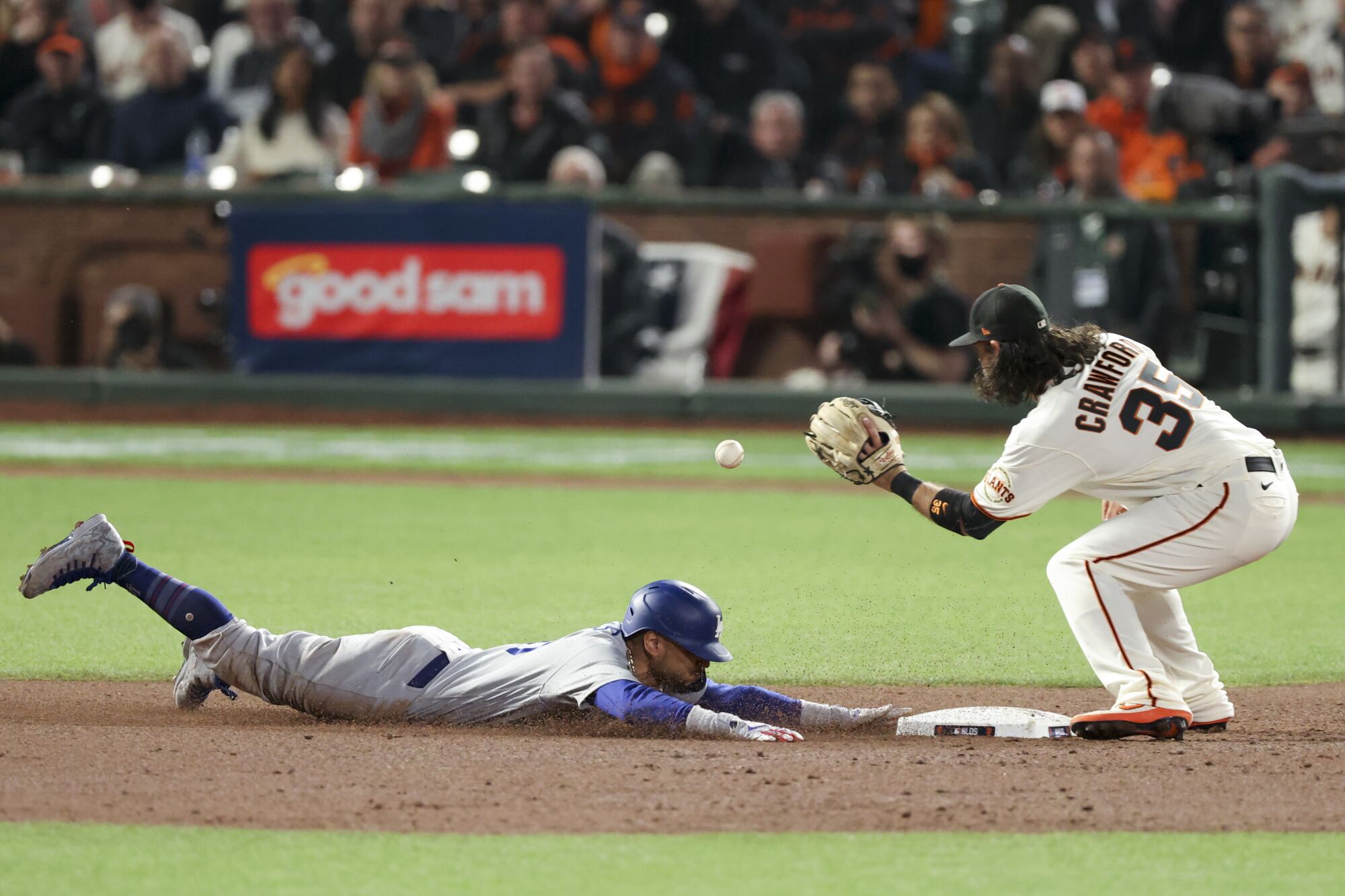 Dodgers' Mookie Betts steals second base ahead of the tag by Giants shortstop Brandon Crawford