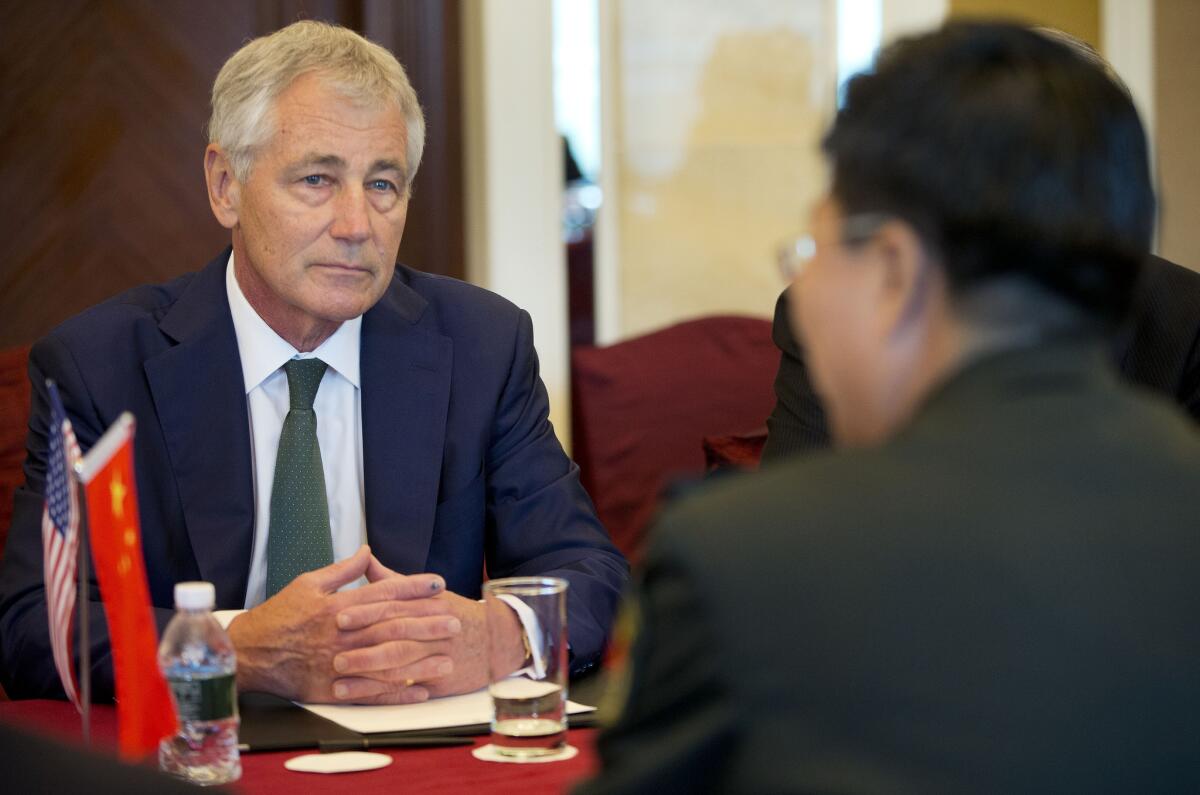 Defense Secretary Chuck Hagel listens to Lt. Gen. Wang Guanzhong, China's deputy chief of general staff, speak at the start of their meeting in Singapore.