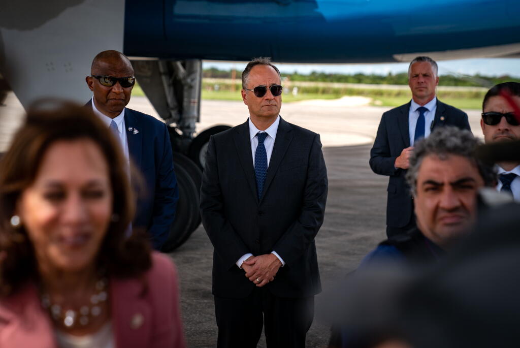 CAPE CANAVERAL, FL - AUGUST 29: Second Gentleman Doug Emhoff stands in the background between Secret Service agents as Vice President Kamala Harris speaks to th