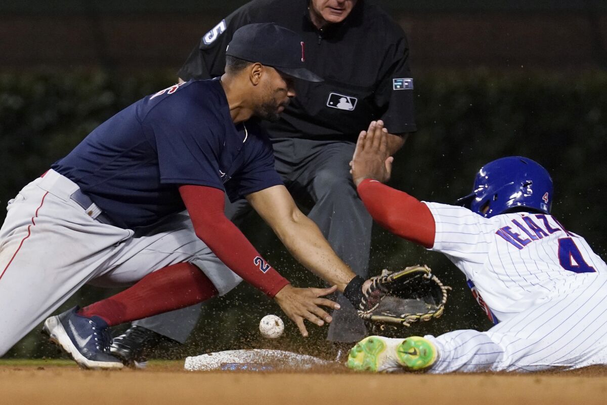 Chicago Cubs' Nelson Velazquez, right, asks for time after second base, next to Boston Red Sox shortstop Xander Bogaerts during the eighth inning of a baseball game in Chicago, Saturday, July 2, 2022. The Cubs won 3-1. (AP Photo/Nam Y. Huh)