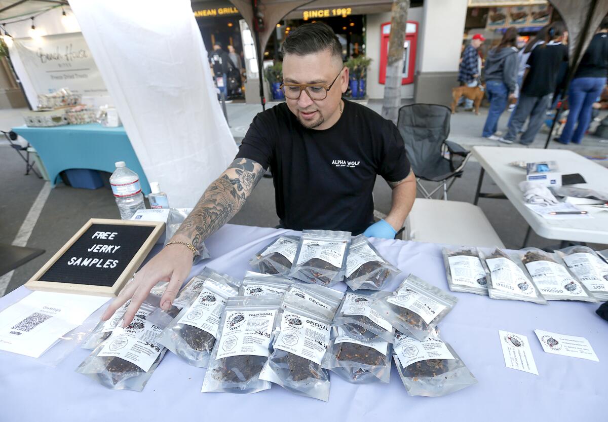 Chris McKnight shares his Alpha Wolf beef jerky during the spring grand opening of Surf City Nights on Tuesday.