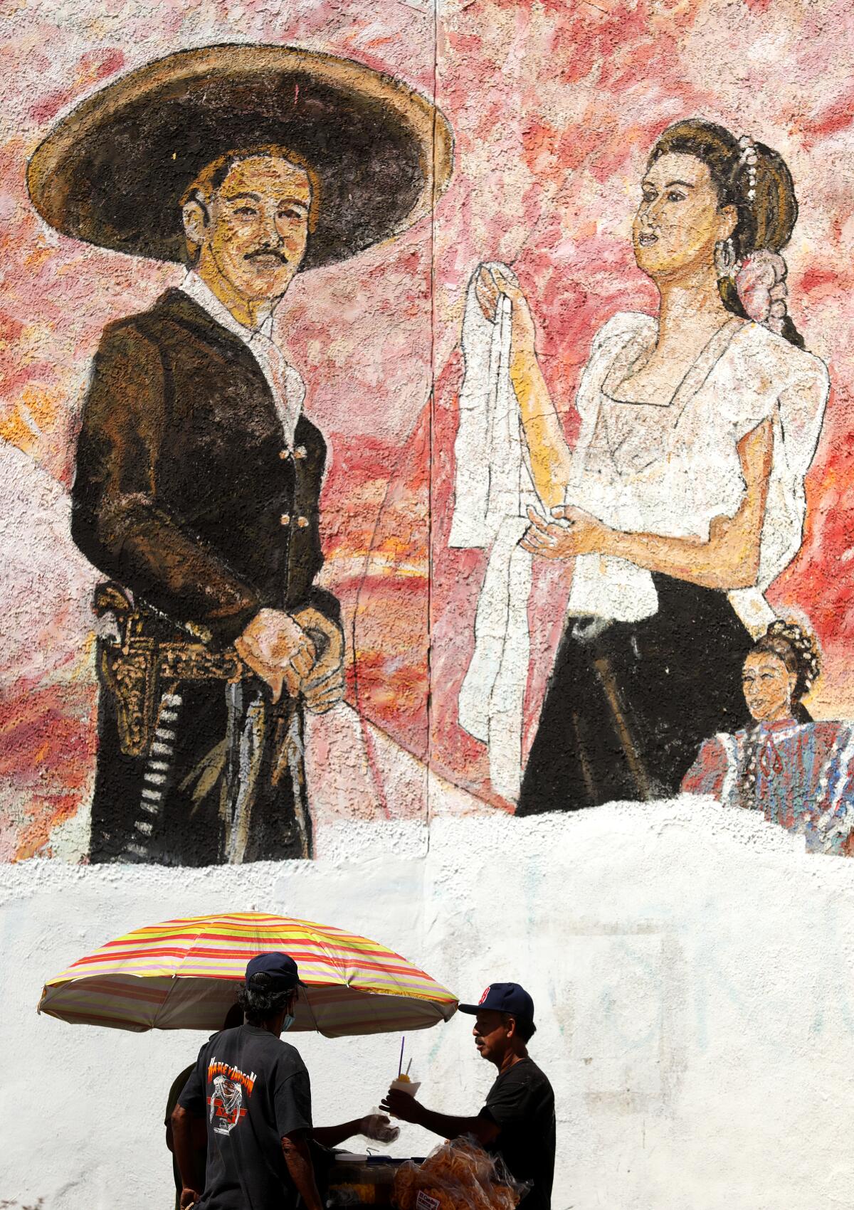 A street vendor sells raspados (shaved ice) in Mariachi Square in Boyle Heights on a summer weekend.