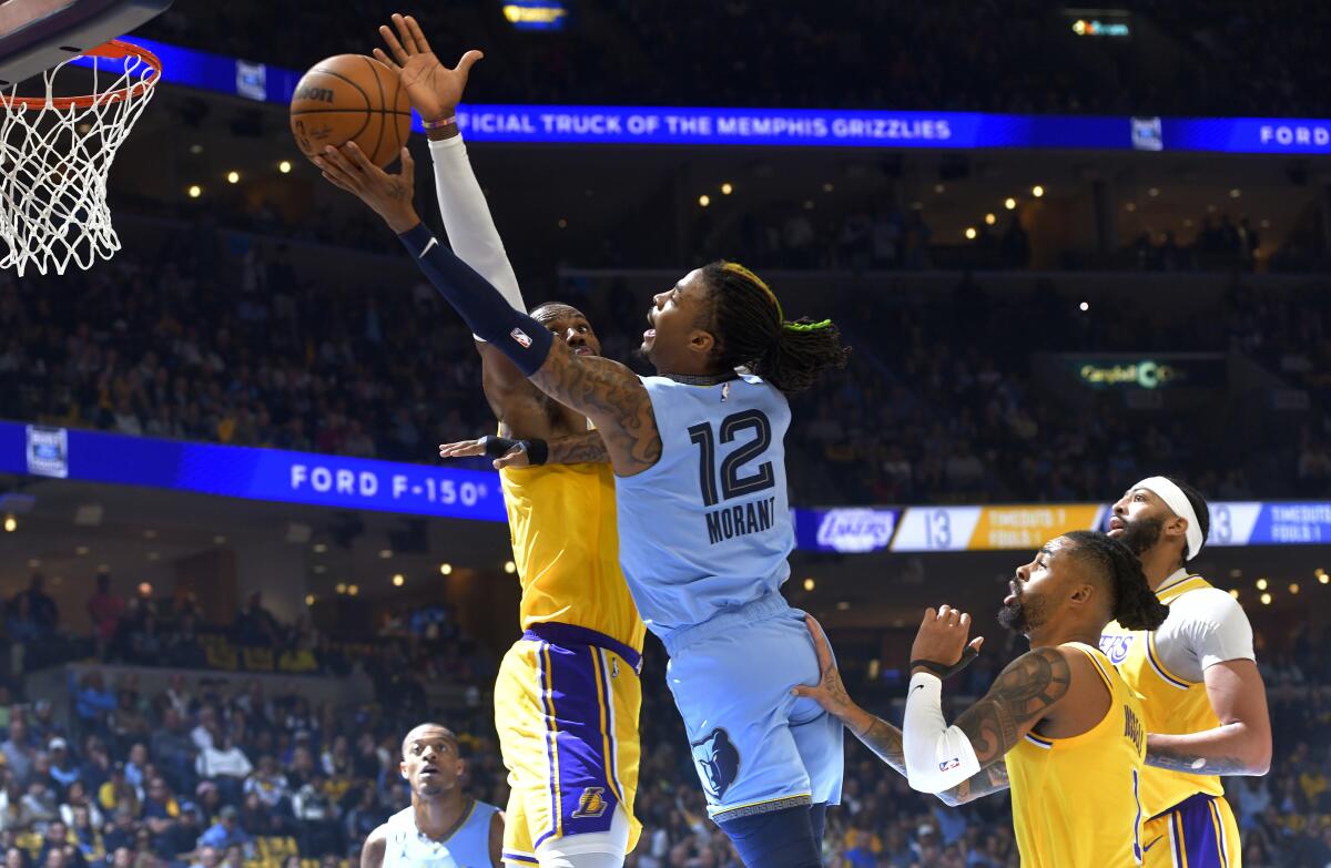Grizzlies guard Ja Morant gets past Lakers forward LeBron James for a layup in Game 5.