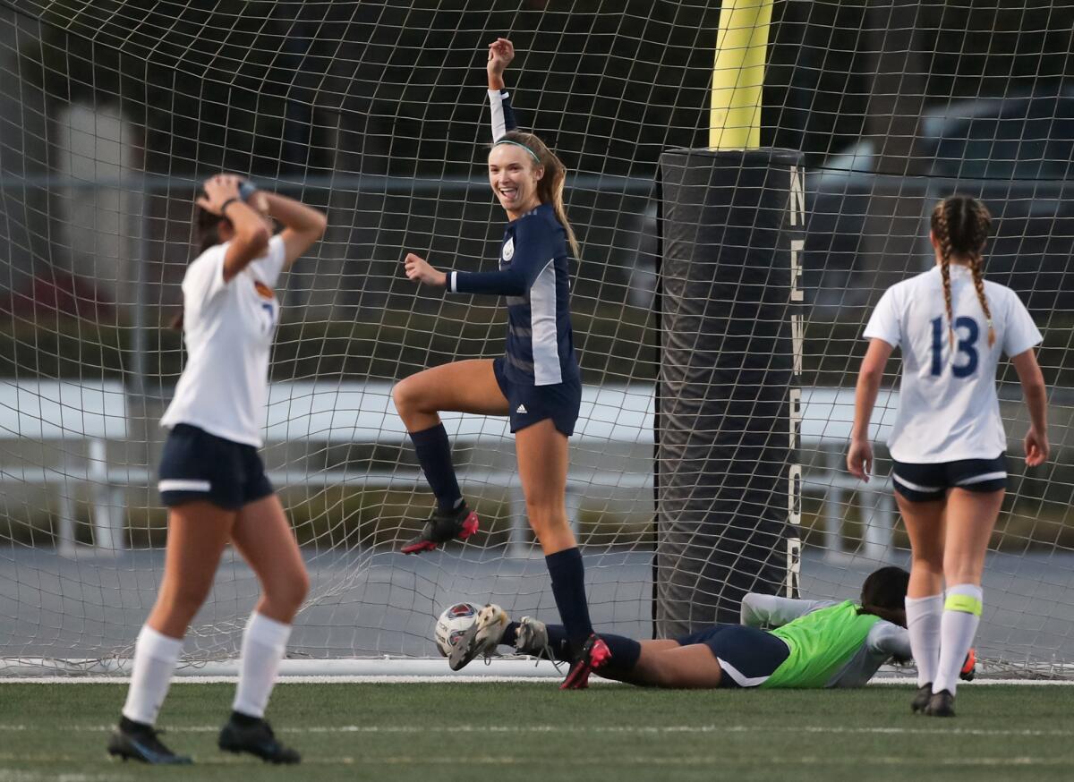Newport Harbor's Laine Briggs, center, is all smiles after scoring a goal against Marina on Tuesday.