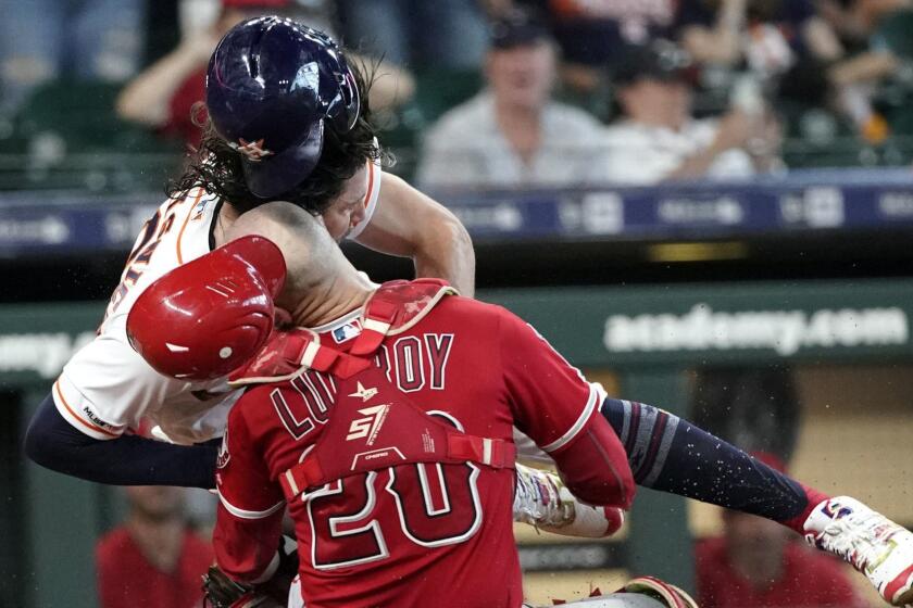 Houston Astros' Jake Marisnick, right, collides Los Angeles Angels catcher Jonathan Lucroy (20) while trying to score during the eighth inning of a baseball game Sunday, July 7, 2019, in Houston. Marisnick was called out under the home plate collision rule. (AP Photo/David J. Phillip)