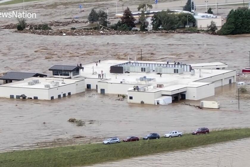 In this image made from a video provided by NewsNation, people can be seen on the roof of the Unicoi County Hospital in Erwin, Tenn., on Friday, Sept. 27, 2024. (NewsNation via AP)