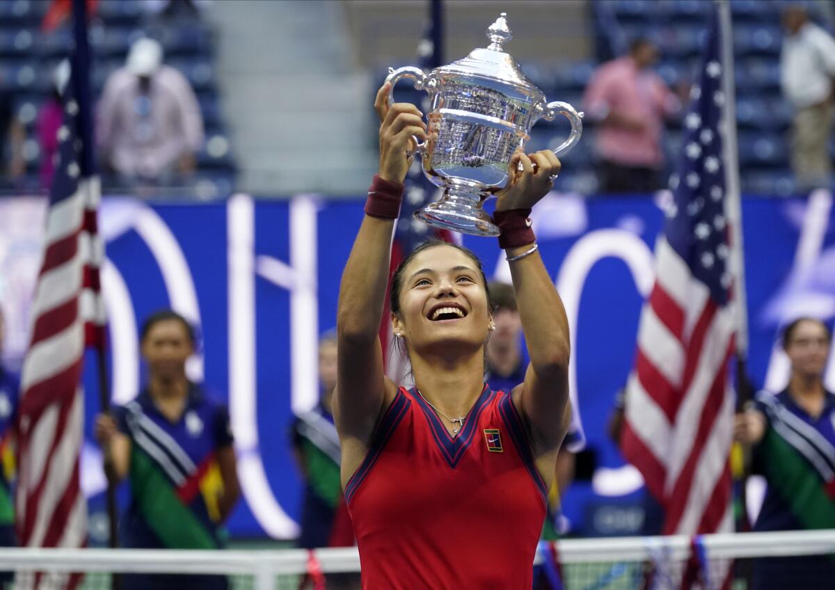 Emma Raducanu, of Britain, holds up the US Open championship trophy after defeating Leylah Fernandez, of Canada, during the women's singles final of the US Open tennis championships, Saturday, Sept. 11, 2021, in New York. (AP Photo/Seth Wenig)