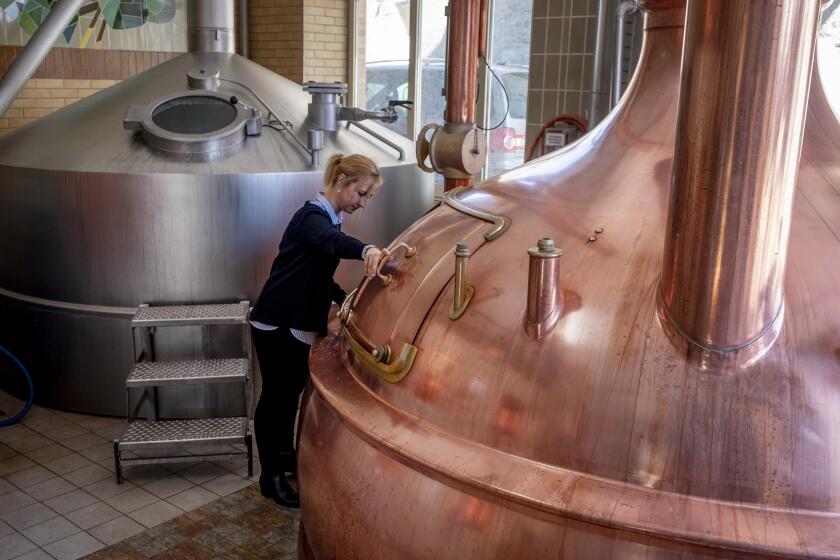 In this , Friday, April 17, 2020 photo junior director Christine Lang of the "Wernecker brewery" stands in the brewhouse of the brewery in Werneck, Germany. Due to the impact of the coronavirus the traditional brewery has to close 400 years after its foundation. (AP Photo/Michael Probst)