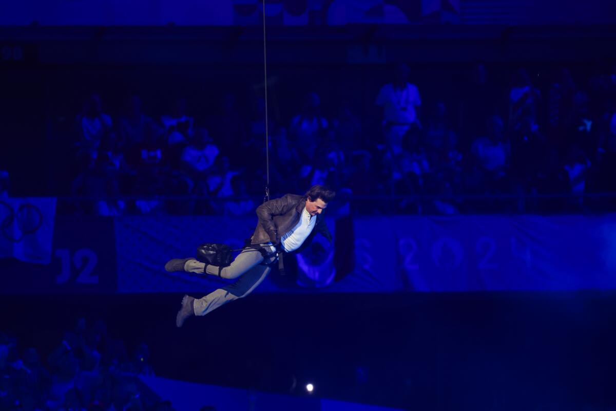 Tom Cruise repels from the top of State de France during the closing ceremony of the 2024 Paris Olympics on Sunday.