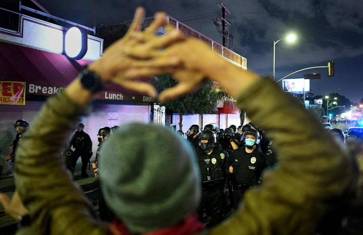 Protestors square-off with LAPD officers on Sunset Blvd. as authorities evict the homeless from Echo Park last March.