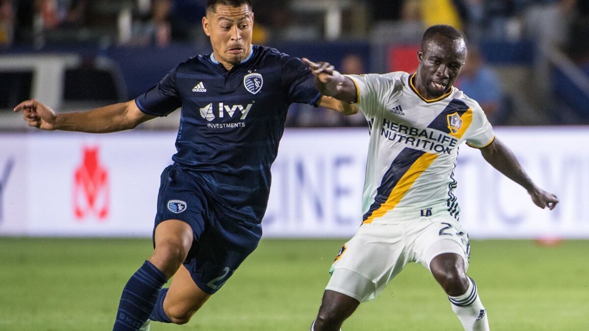 Galaxy's Ema Boateng, right, with the ball as Sporting Kansas City's Roger Espinoza defends during the match at the StubHub Center on June 24, 2017, in Carson.