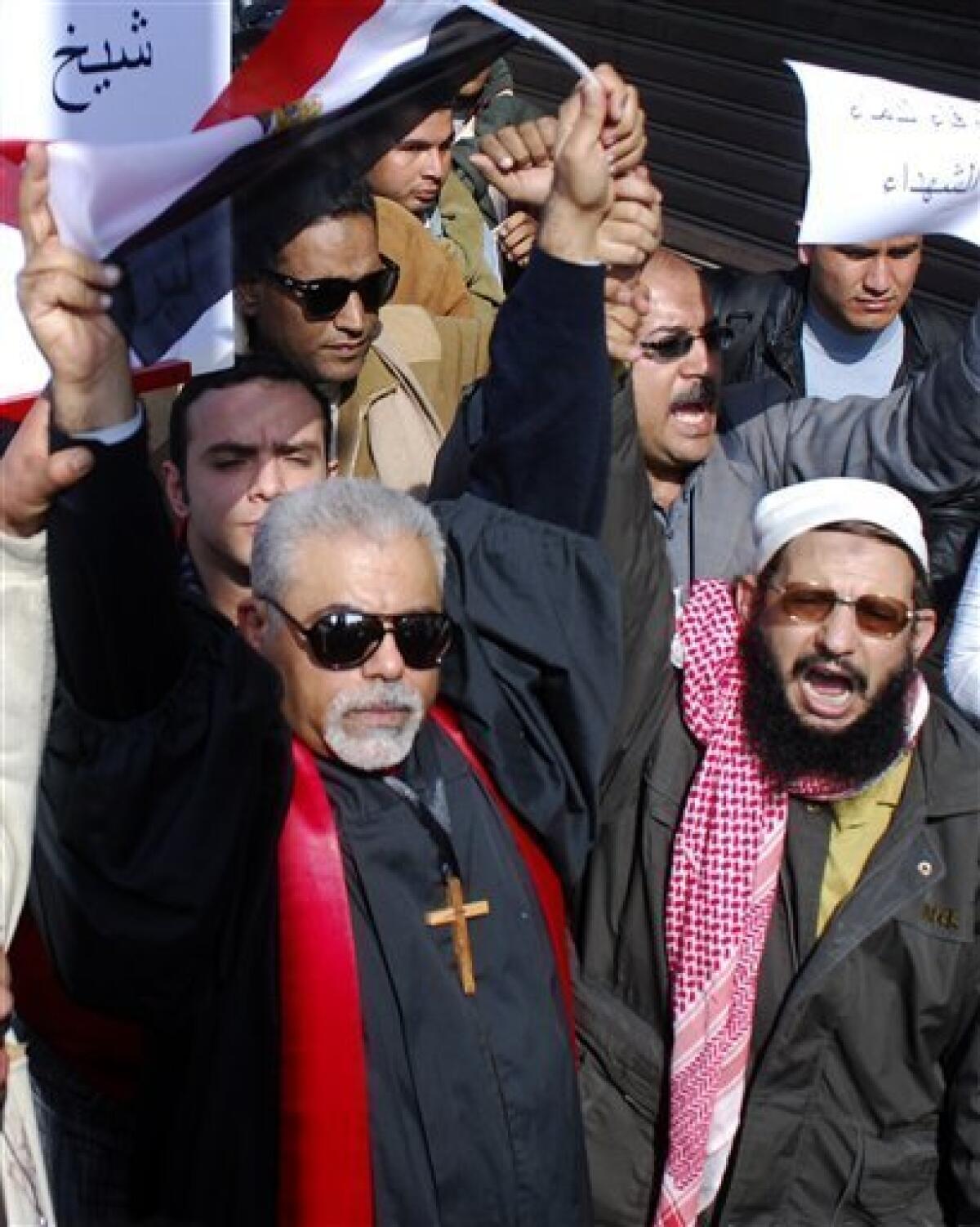 A Christian Coptic priest, left, and other demonstrators arrive in Tahrir, or Liberation, Square in Cairo, Egypt, Tuesday, Feb. 1, 2011. Security officials say authorities have shut down all roads and public transportation to Cairo, where tens of thousands of people are converging to demand the ouster of Egyptian President Hosni Mubarak after nearly 30 years in power. (AP Photo/Mohammed Abu Zaid)