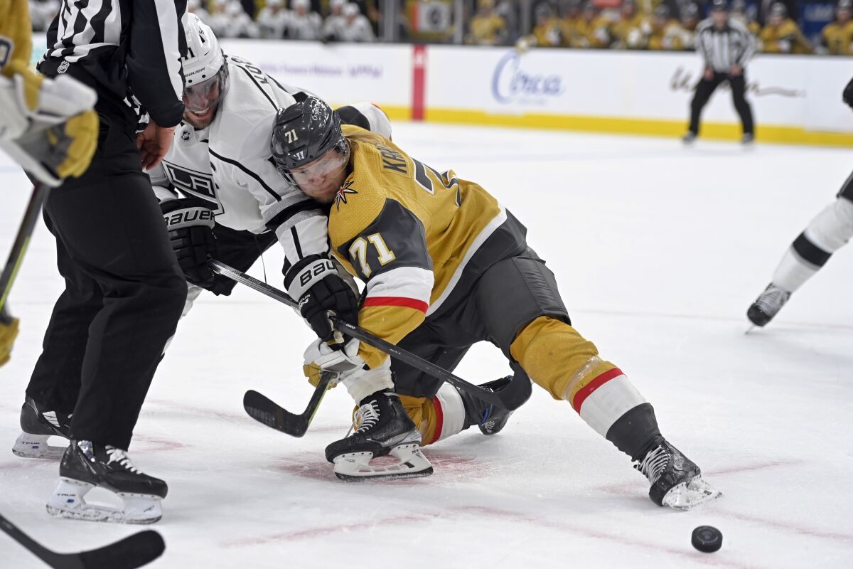 Los Angeles Kings center Anze Kopitar (11) and Vegas Golden Knights center William Karlsson (71) vie for the puck after a faceoff during the first period of an NHL hockey game Friday, Feb. 18, 2022, in Las Vegas. (AP Photo/David Becker)