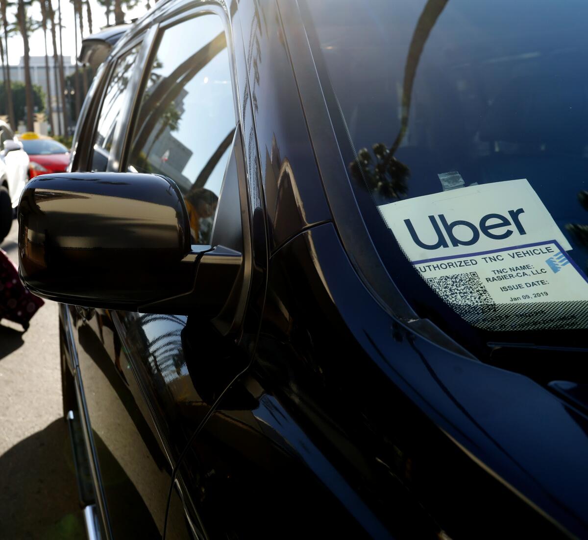 A car has an Uber sticker attached to its windshield.