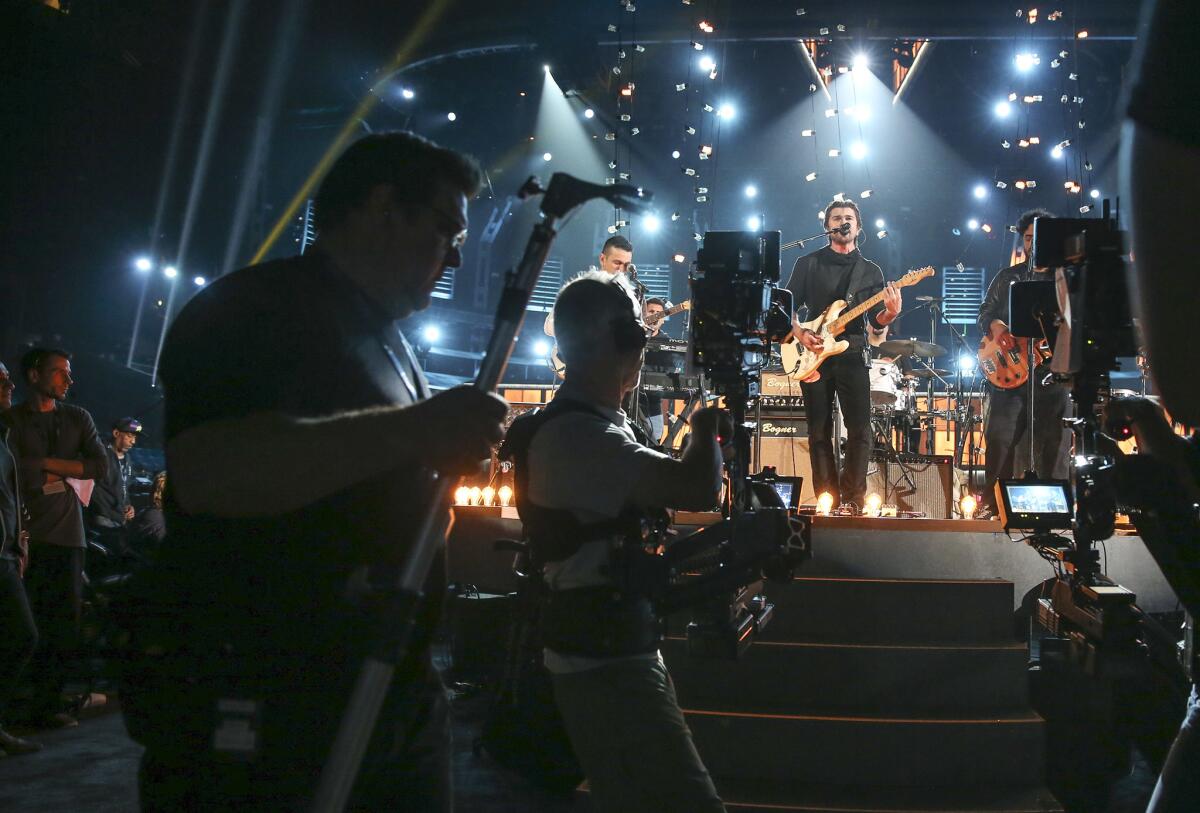 The crew puts a final buff and polish on the Grammy telecast's first Spanish-language performance in a decade, delivered by Colombian rock star Juanes, center.