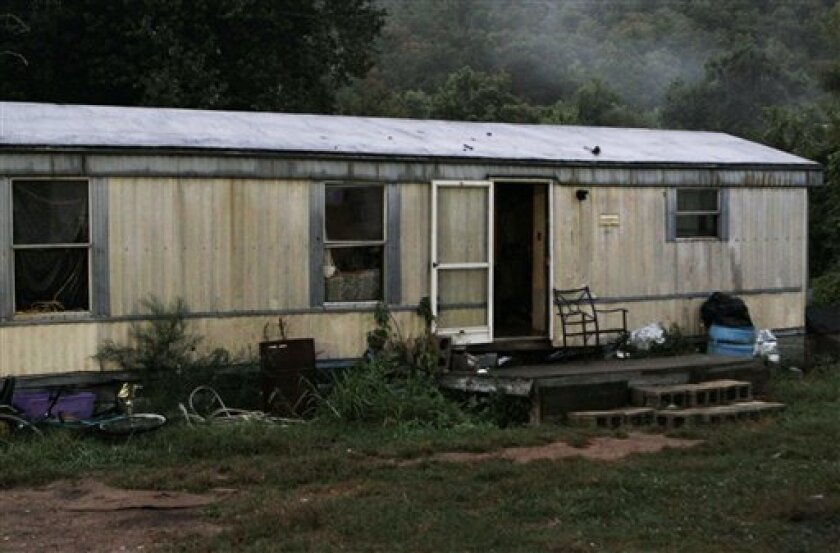 The door remains open after neighbors say Stanley Neace kicked it in and killed four people in the trailer in a shooting rampage that left a total of five people and Neace dead in Jackson, Ky., Saturday, Sept. 11, 2010. (AP Photo/Ed Reinke)