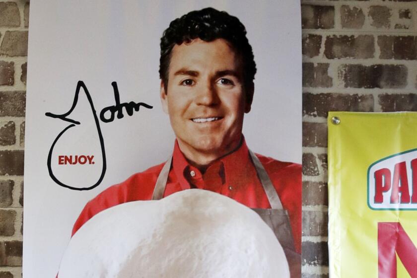 FILE- In this Dec. 21, 2017, file photo shows signs, including one featuring Papa John's founder John Schnatter, at a Papa John's pizza store in Quincy, Mass. Schnatter is no longer board chairman after using a racial slur, but his image is still part of the pizza chain's logo and he remains the company's largest shareholder. (AP Photo/Charles Krupa, File)