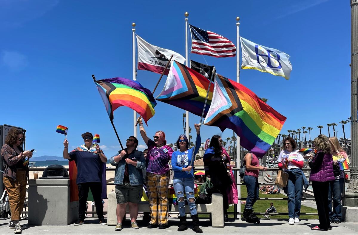 Local activists wave Pride flags at the Huntington Beach Pier in May. 