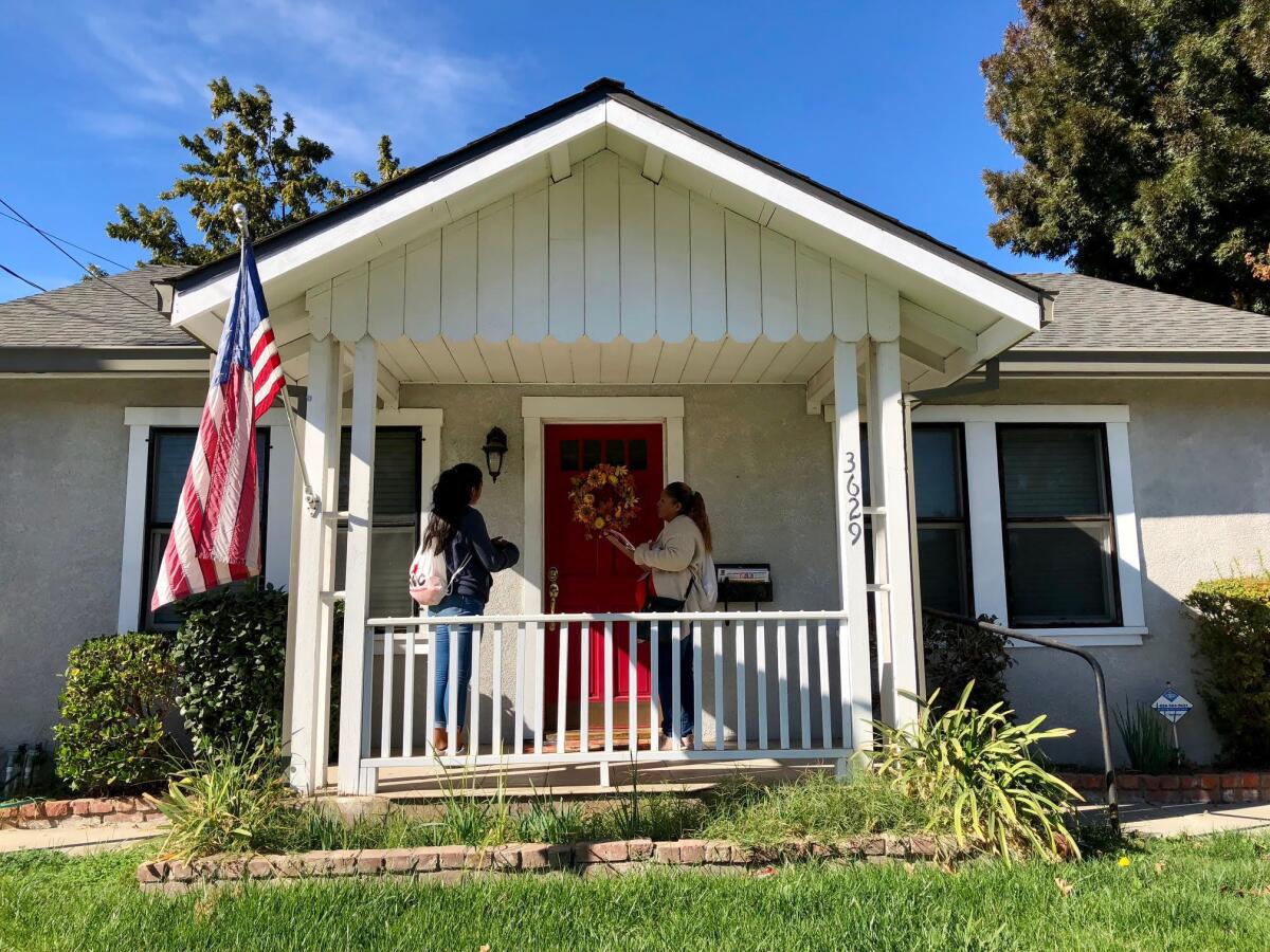 Cristina Escobedo, 41, and Cristal Reyes, 16, make a final push for Democrat Josh Harder by knocking on doors in the town of Ceres, Calif.