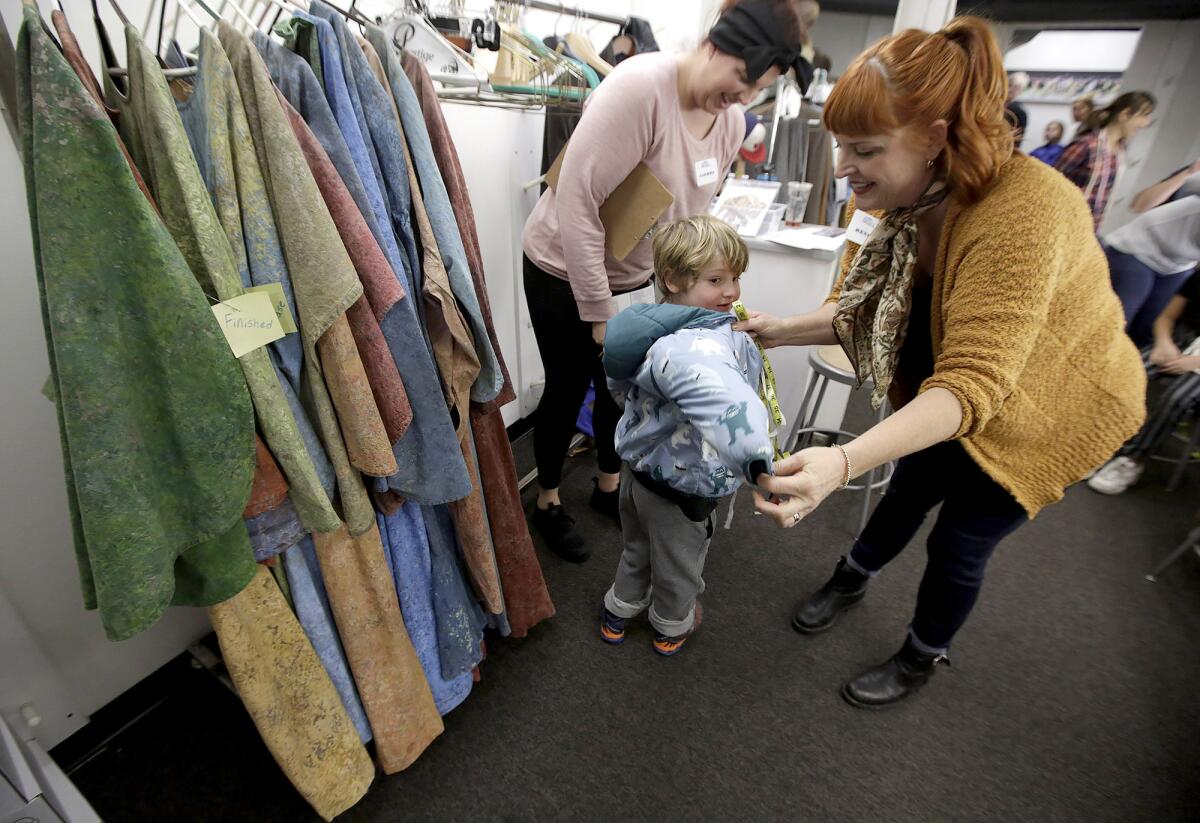 Volunteers Cierra Maciel, left, and Rene Gonzalez measure Niki Eide, 5, during the open casting call for the 2020 Pageant of the Masters on Friday in Laguna Beach. The casting call continues through Sunday.