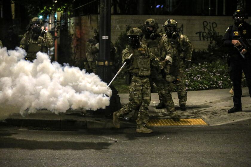 Militarized federal agents deployed by the president to Portland, fired tear gas against protesters again overnight Friday, July 17, 2020 in Portland, Ore. as the city’s mayor demanded that the agents be removed and as the state’s attorney general vowed to seek a restraining order against them.(Dave Killen/The Oregonian via AP)