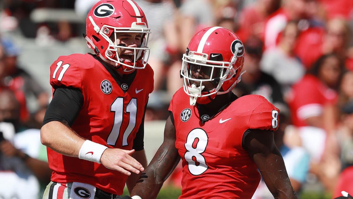 Georgia quarterback Jake Fromm (11) and wide receiver Riley Ridley (8) celebrate after connecting for a 10-yard touchdown reception against Austin Peay during the first quarter on Saturday.